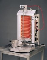 Das Bild zeigt das eingeschaltete Gerät auf einem kleinen Metalltisch vor dunkelgrauem Hintergrund von schräg vorne. Das Bild zeigt das eingeschaltete Gerät auf einem kleinen Metalltisch vor dunkelgrauem Hintergrund von schräg vorne.