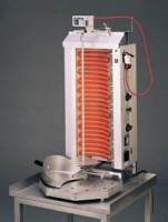 Foto des aktivierten Dönergrills / Gyrosgrills auf einem Edelstahltisch. Die Heizschlange ist rotglühend und auf der Foto des aktivierten Dönergrills / Gyrosgrills auf einem Edelstahltisch. Die Heizschlange ist rotglühend und auf der Fettwanne liegt eine Dönerschaufel. Der Hintergrund ist ein Verlauf von Dunkelgrau zu Mittelgrau von oben nach unten.